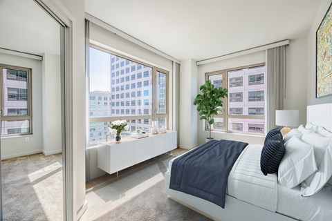 Bright bedroom with corner windows and city views at The Grand Apartments, Oakland, California